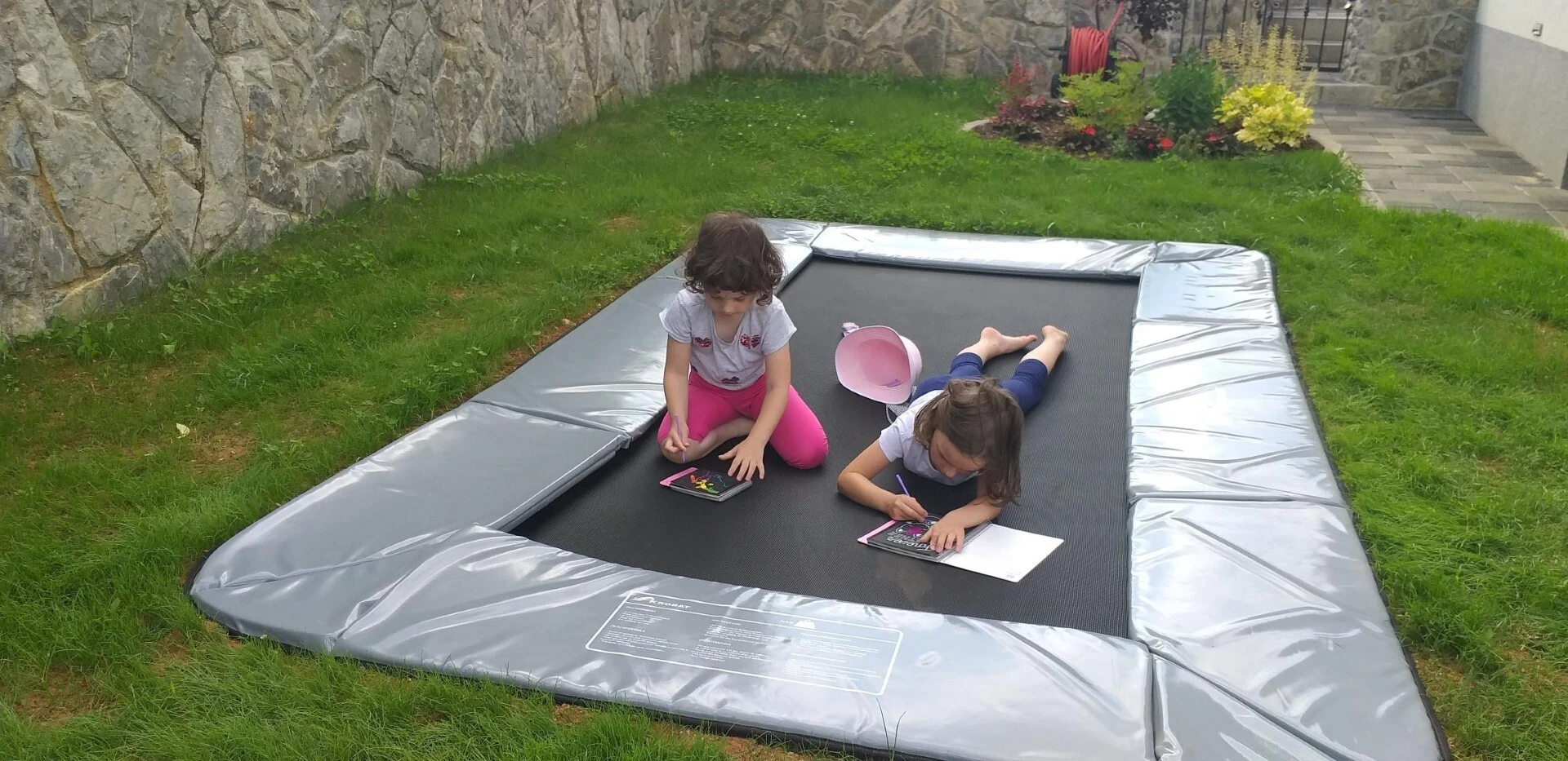 Customer photo of an Akrobat Primus Flat rectangular trampoline installed in a garden