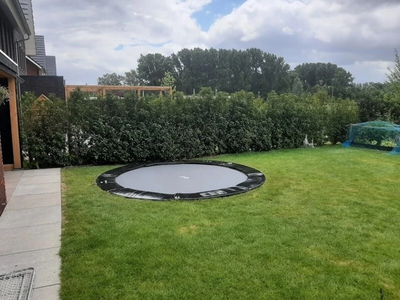 Customer photo of an Akrobat Primus Flat round trampoline installed in a garden