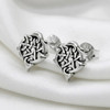 Wiccan heart pentacle post earrings resting on elegant white silk for a romantic, pagan jewelry aesthetic