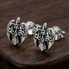 Raven Post Earrings: Detailed silver bird design displayed against a rich, dark wooden surface