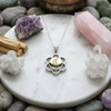 Svadhisthana necklace draped over a sage smudge stick bundle to emphasize its spiritual and healing purpose