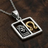 Leo pendant zodiac jewelry, displaying a two-tone silver and gold horoscope design resting elegantly on a warm, dark wood grain surface