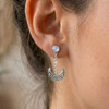 Moonstone moon earrings highlighting the iridescent blue flash of the rainbow moonstone stud worn elegantly on a model's ear