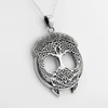 Left-angle close-up of a Celtic tree pendant, emphasizing the detailed woven roots and branches of this sterling silver tree pendant and Celtic tree necklace