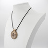 Bronze Pagan wheel necklace displayed on a white jewelry bust, demonstrating the hanging scale and black cord of this detailed magical astrology pendant
