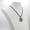 Large Gold Pentacle necklace displayed elegantly on a white jewelry bust, showcasing the black cord and the hanging scale of this solid bronze pendant