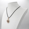 Bronze Cho Ku Rei pendant displayed elegantly on a white jewelry bust, showcasing the black cord and hanging scale of this wellness amulet