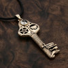Large magic key pendant in gold-colored bronze, featuring a pentagram, yin-yang, and cauldron design, resting on a dark wood background at our witchcraft store