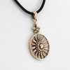 Nature jewelry piece showing a close-up of the gold sun pendant angled to the left, focusing on the central dome and geometric sunburst rays
