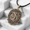 Celtic tree pendant draped elegantly across bright white marble steps at our pagan jewelry store, emphasizing the polished gold tone and complex world tree design