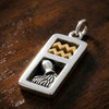 Aquarius charm necklace featuring a rectangular sterling silver pendant with gold vermeil wave symbols and a silver water pitcher