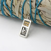 Close-up of an Aquarius zodiac pendant resting on a dark wood surface, highlighting the polished silver and gold details