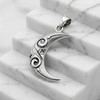 Large crescent moon pendant resting gracefully on white marble steps, a striking modern moon pendant necklace at our witch supply store
