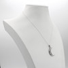 Crescent moon necklace displayed on a white jewelry bust, an elegant modern moon pendant cast in polished .925 sterling silver