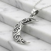 Oxidized sterling silver moon pendant resting gracefully on white marble steps, an elegant stylized moon necklace shaped like a textured crescent moon