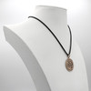 Celtic trinity knot pendant displayed elegantly on a white jewelry bust, showcasing the black cord and the hanging scale of this large bronze necklace