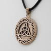 Celtic jewelry piece showing a close-up angled to the left, focusing on the seamless, interlocking lines of the bronze triquetra pendant and its decorated bail