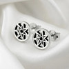 Faery star studs capturing a sleek, woven seven-pointed aesthetic, displayed gracefully on folded, smooth white silk fabric