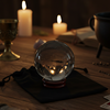 Crystal ball with divination Tools and witchcraft supplies in a dimly lit room.