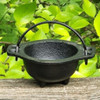Baby Witch Cauldron: witchcraft supplies & wiccan ritual tools. Witches cauldron close up and outside, midsummer, natural light.