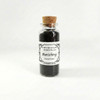 Front view of a glass vial containing black Banishing Incense Powder by Witchcraft Essentials against a white background.
