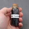 Black Tourmaline amulet witch jar, pagan, wiccan, and witchcraft metaphysical store supplies with pentacle charm held in practitioners hand ready for spell work