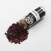 Garnet amulet witch jar, pagan, wiccan, and witchcraft metaphysical store supplies with pentacle charm spilled on white witches altar.