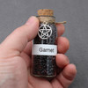 Garnet amulet witch jar, pagan, wiccan, and witchcraft metaphysical store supplies with pentacle charm held in practitioners hand ready for spells and rituals
