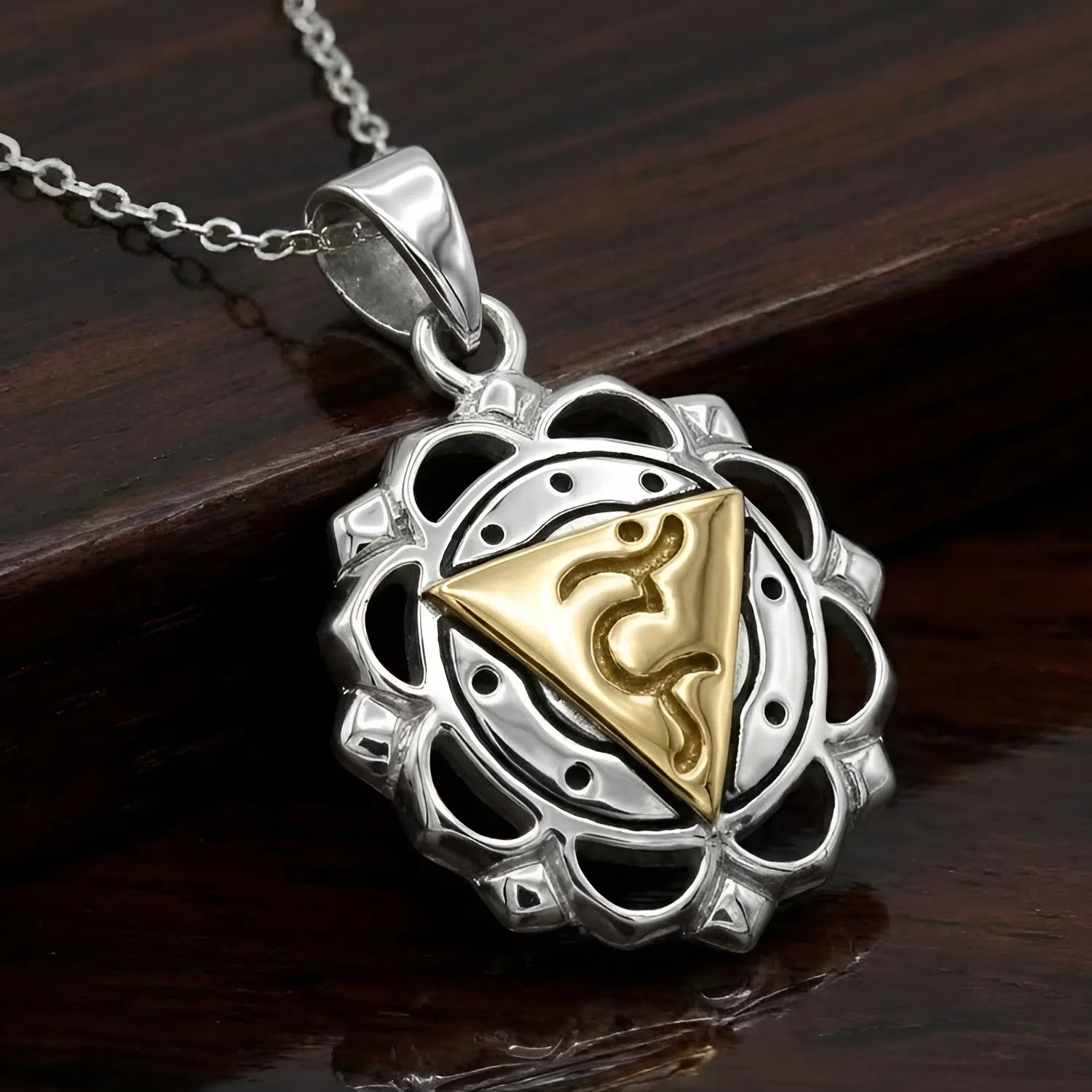 Chakra pendant for the Throat Chakra at our pagan jewelry store resting at an angle on a dark wood background