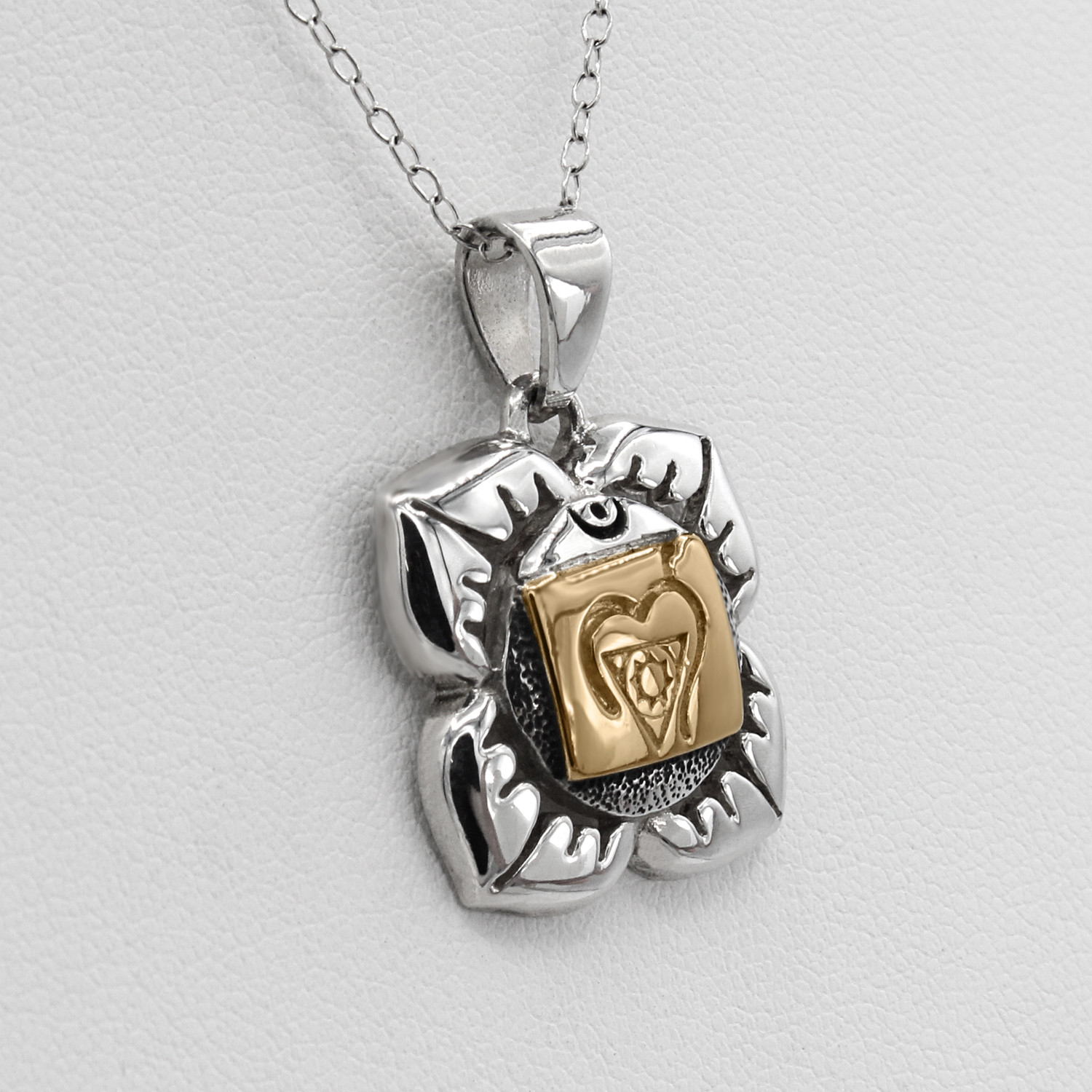 Root Chakra jewelry piece in sterling silver showing the textured, oxidized detailing behind the gold crest