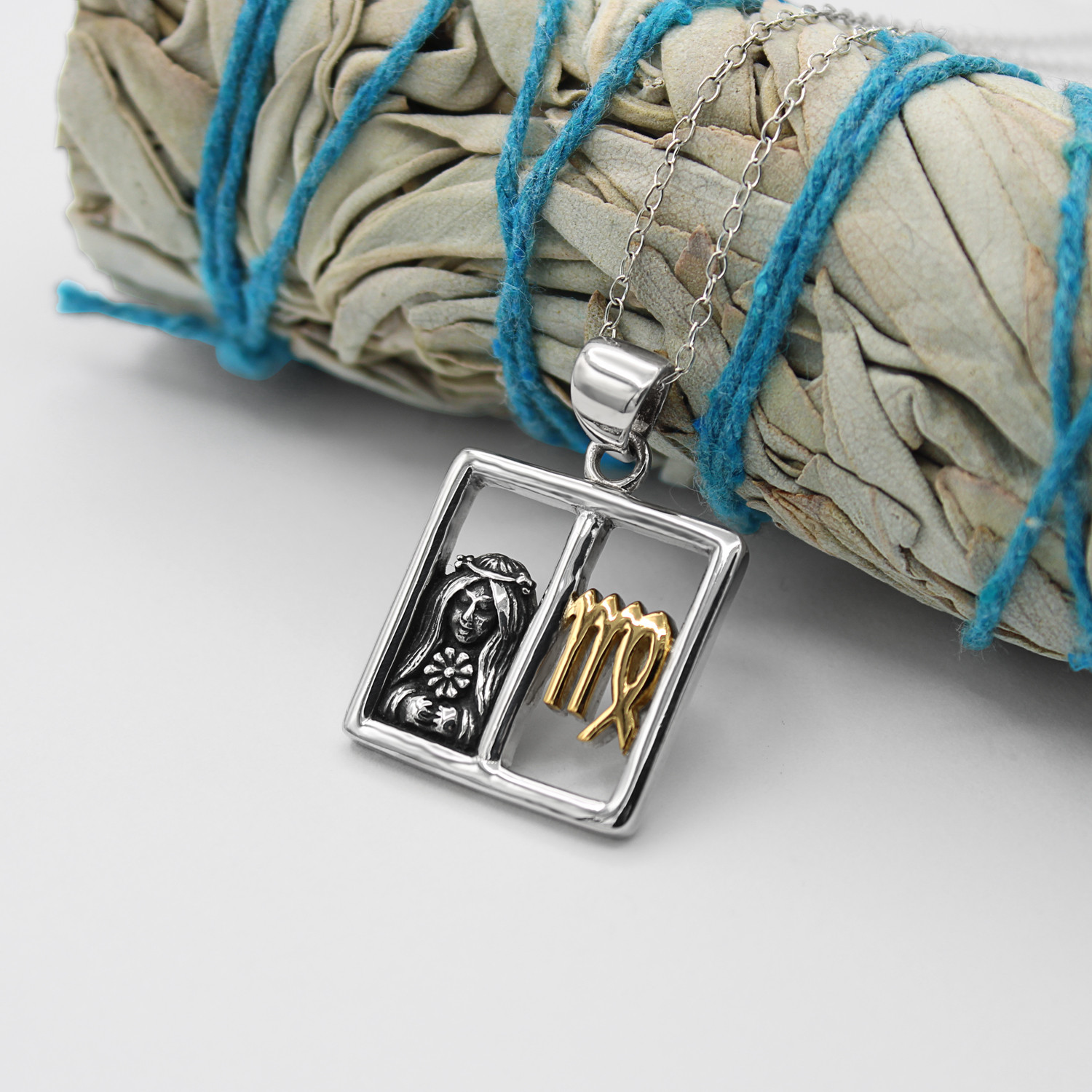 Virgo jewelry mystical horoscope necklace draped delicately over a bundle of dried sage, showcasing the high-quality .925 sterling silver and gold craftsmanship