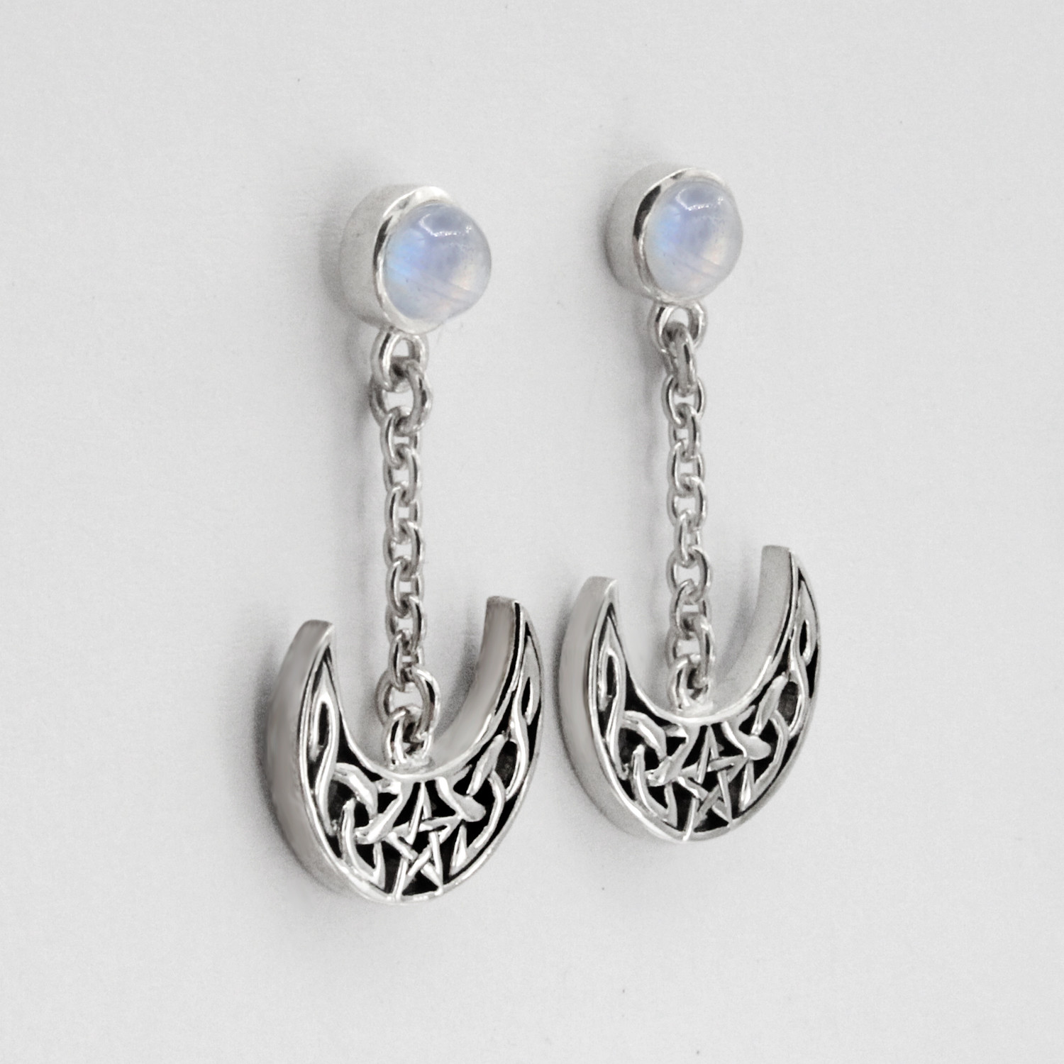 Moon and star earrings featuring a Celtic knotwork crescent and a central pentacle, shown lying flat with polished sterling silver backings
