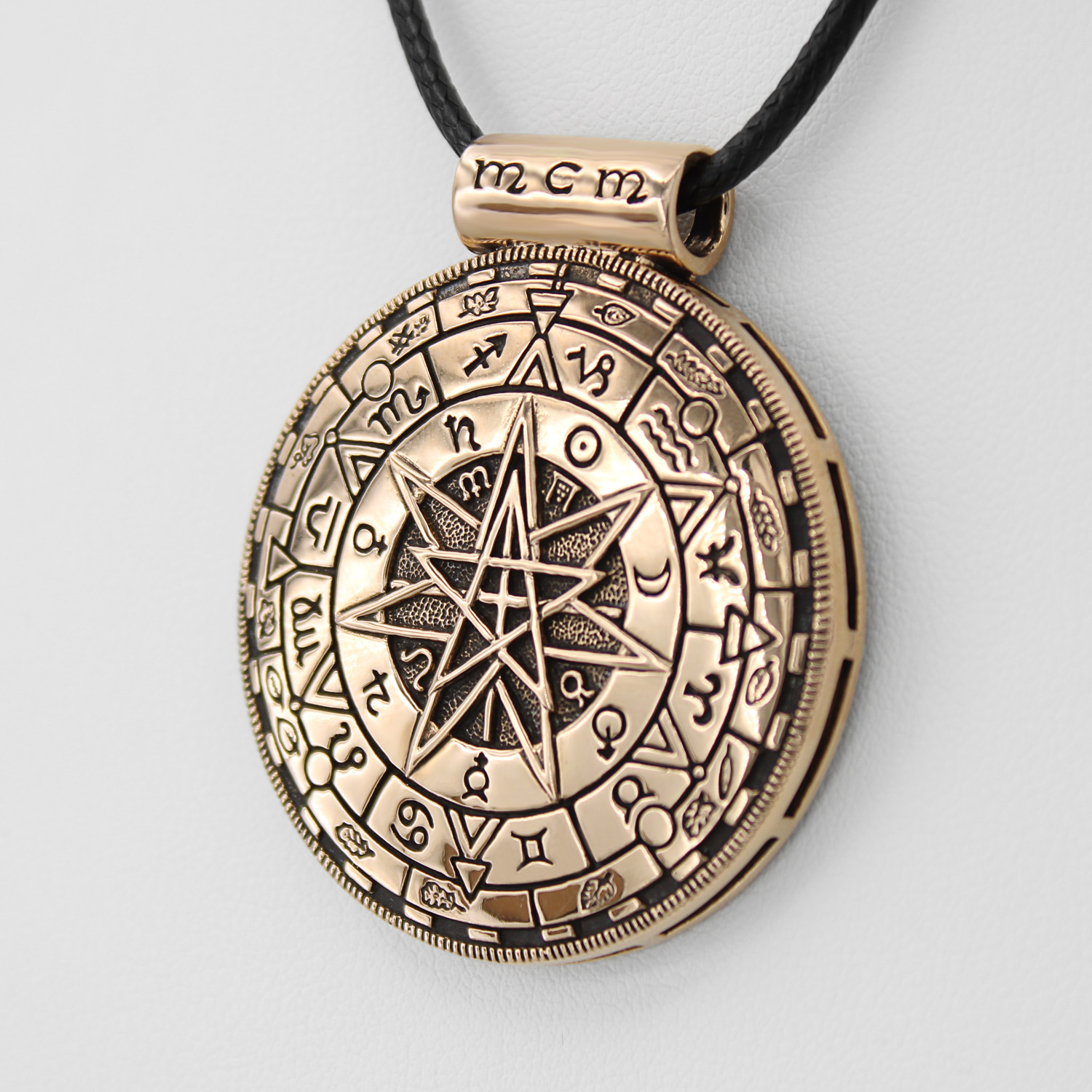 Magic Circle Necklace close-up angled to the left, emphasizing the polished gold-tone finish, planetary symbols, and the central heptagram star design