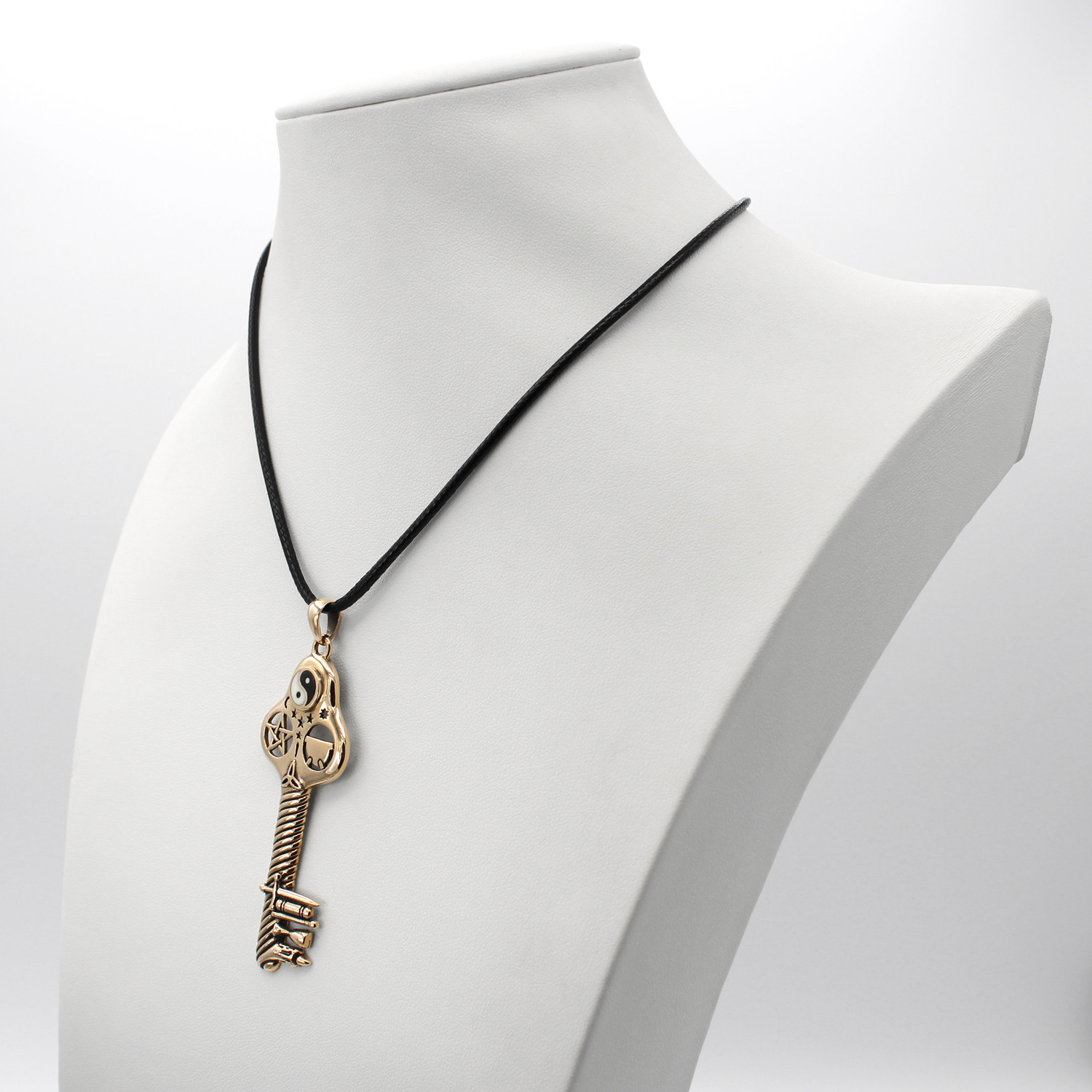 Witchcraft key pendant in bronze, beautifully displayed on a white jewelry bust to highlight the black cord and the scale of the Wicca symbol pendant