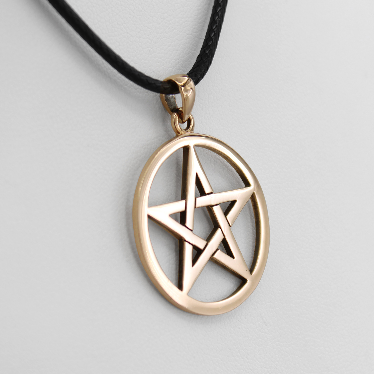 Pagan pendant close-up angled to the left, emphasizing the clean lines and open star design of the gold pentacle