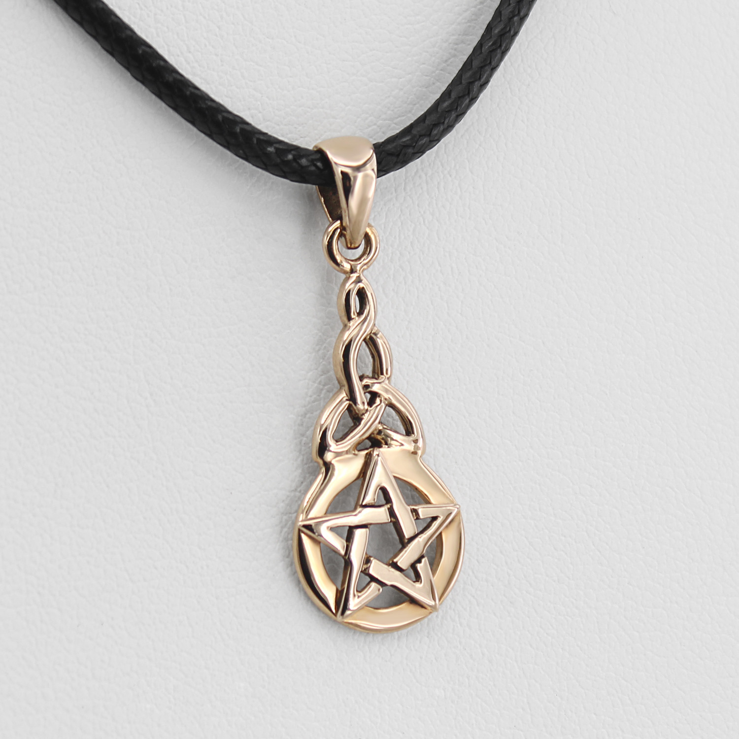 Witch jewelry featuring a close-up angled to the left, showing the smooth, intertwining golden bronze loops of the trinity knot pentagram necklace