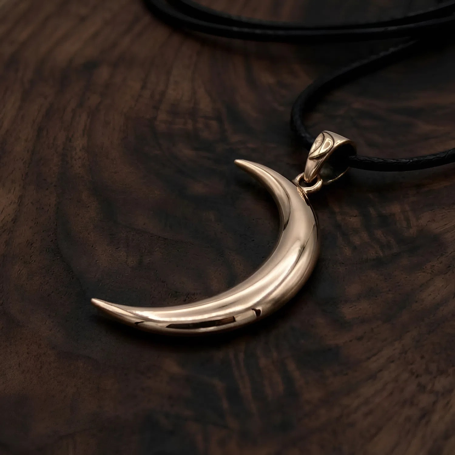 Wiccan moon necklace in a brilliant gold-colored bronze, focusing closely on the clean, minimalist lines of the classic crescent shape