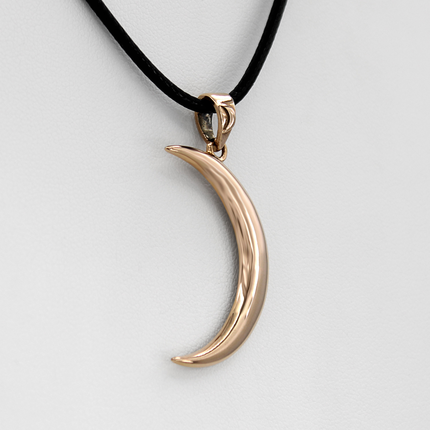 Gold moon pendant close-up angled to the left, showing the beautifully rounded, smooth face of the celestial bronze crescent moon pendant