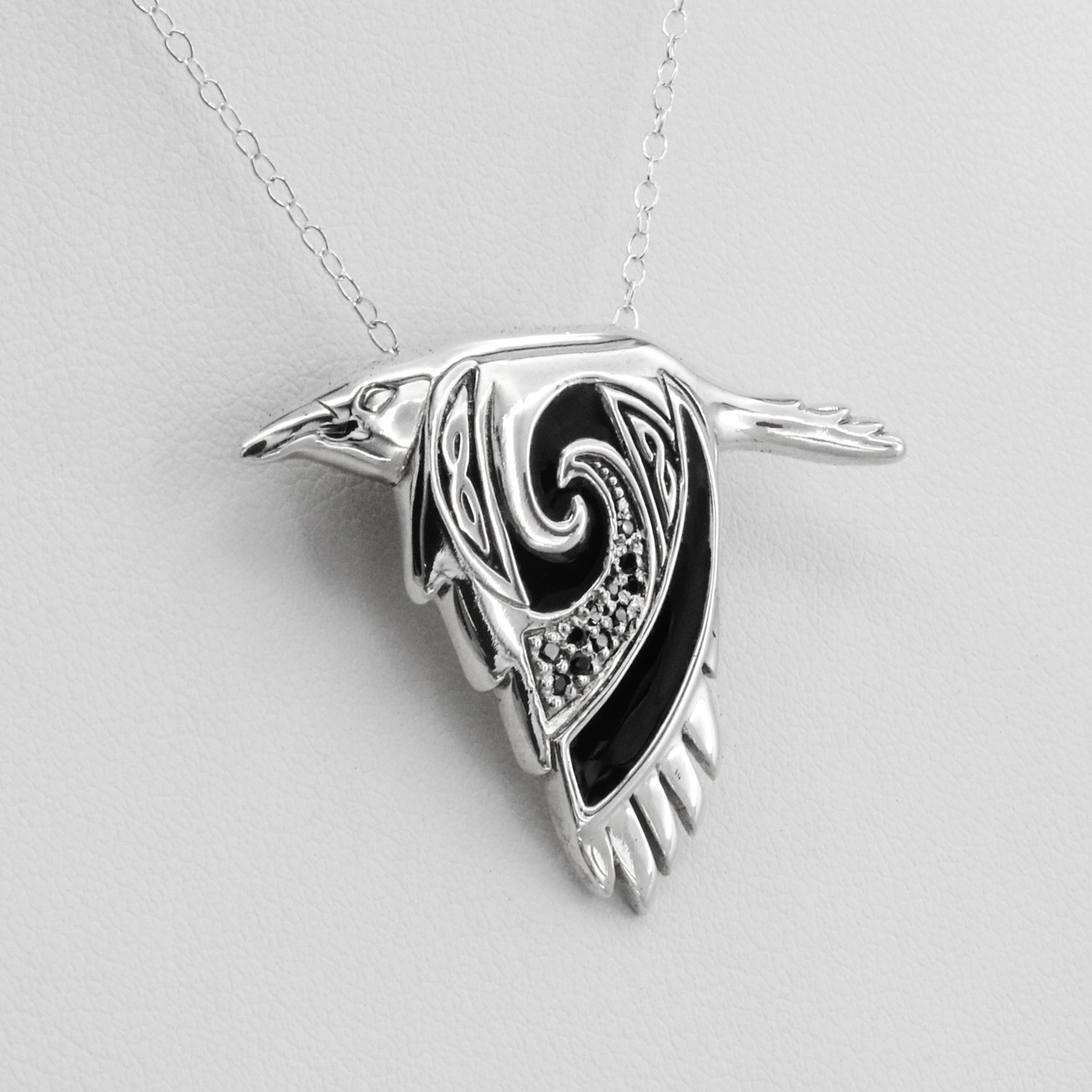 Celtic crow necklace, a close-up angled to the right, emphasizing the sterling silver spirit animal's detailed wing and smooth polished finish