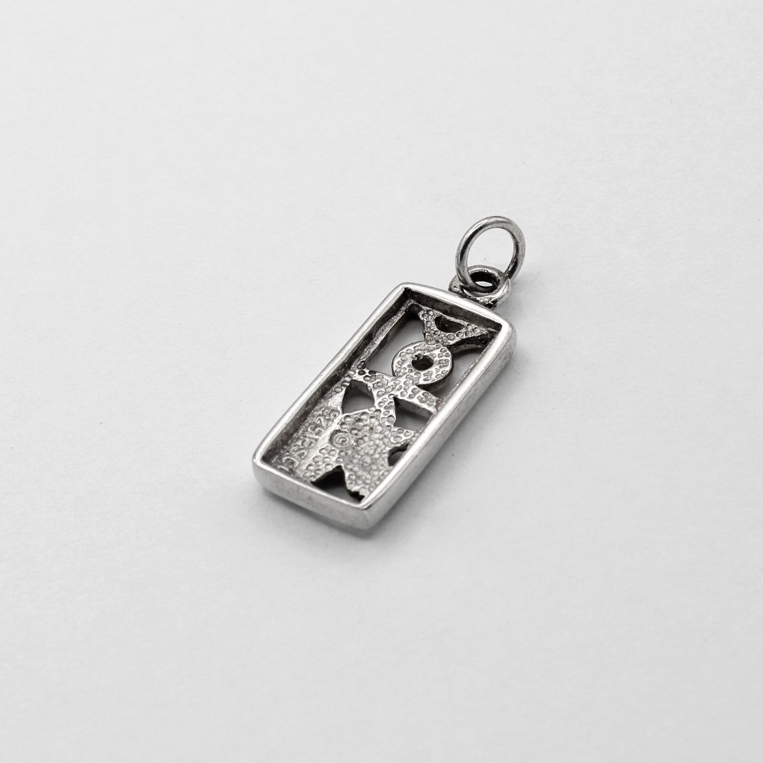 Back view of Taurus-themed jewelry piece showing textured back and .925 sterling silver hallmark stamp.