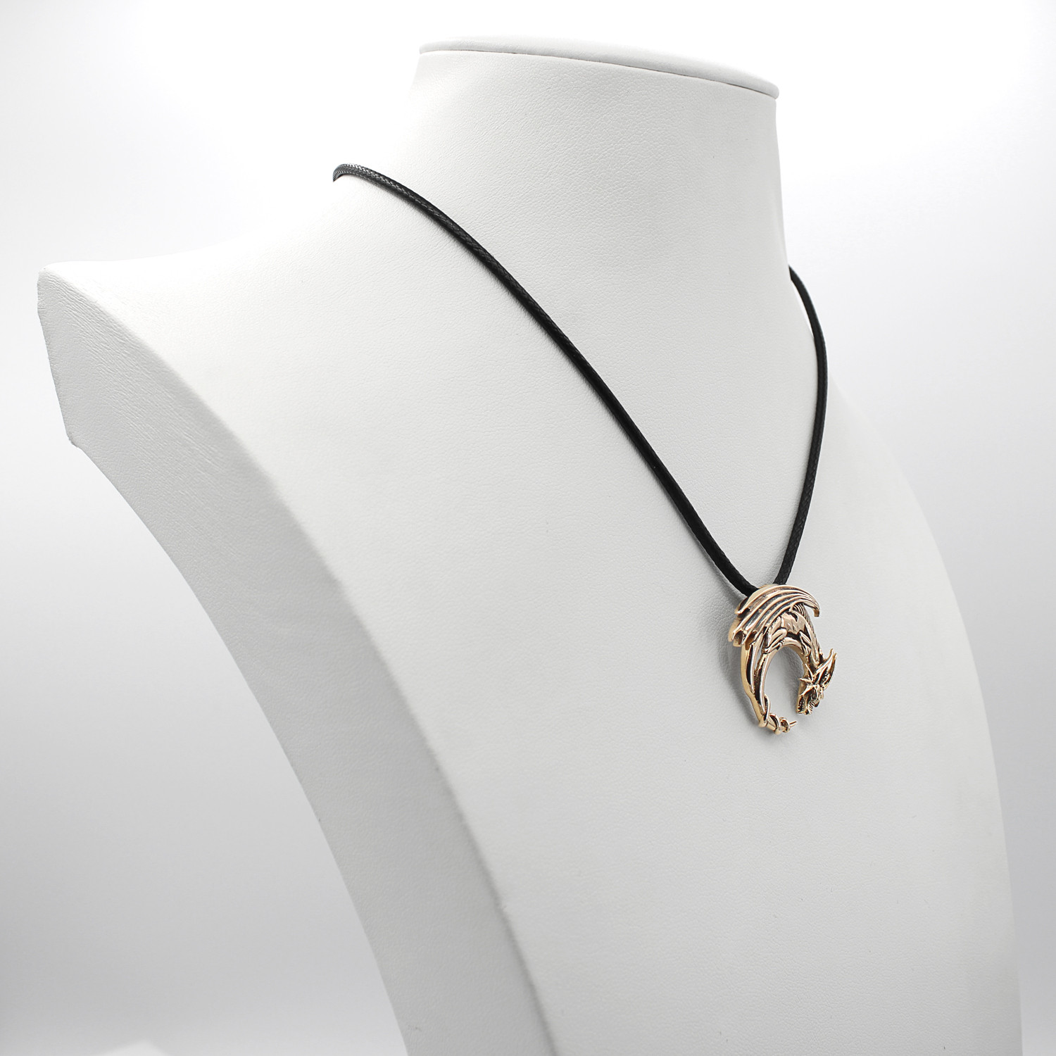 Gold dragon necklace displayed gracefully on a white jewelry bust, showcasing the black cord and the hanging scale of the crescent moon dragon pendant