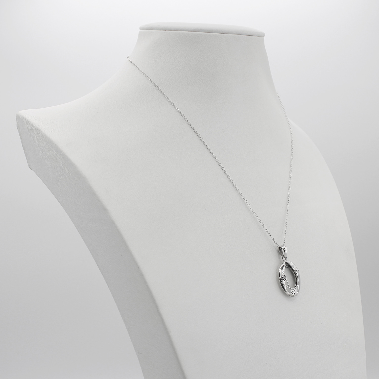 Modern Celtic jewelry featuring a delicate .925 sterling silver Celtic trinity knot pendant displayed on a white jewelry bust