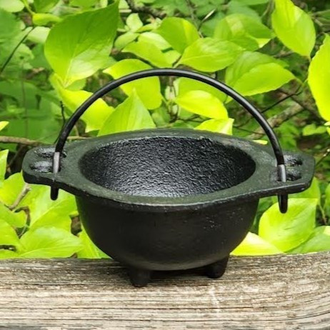 Baby Witch Cauldron: witchcraft supplies & wiccan ritual tools. Witches cauldron close up and outside, midsummer, natural light.