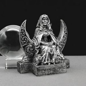 Small Moon Goddess statue by Dryad Design in a silver finish, sitting in front of a Celtic crescent moon next to a clear crystal ball
