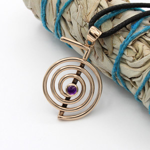 Cho Ku Rei necklace at our witchcraft jewelry store resting against a bundled white sage smudge stick, capturing the esoteric, spiritual essence of this bronze and amethyst jewelry