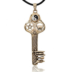 Witches key necklace, a large gold-bronze witchcraft key hanging straight against a bright white background, showing its intricate Wicca symbols