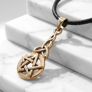 Celtic pentacle pendant at our Wiccan jewelry store crafted in a polished gold-tone bronze, resting elegantly across white marble steps to highlight the seamless knotwork design