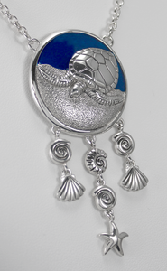 This large Sea Witch necklace features a turtle familiar animal against a vibrant blue enamel background, accented by dangling shells and five pointed star This large Sea Witch necklace features a turtle familiar animal against a vibrant blue enamel background, accented by dangling shells and five pointed star