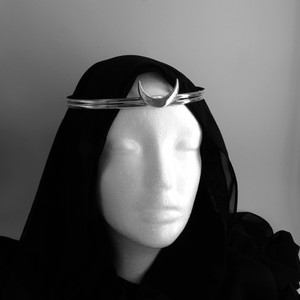This elegant sterling silver ritual circlet is more than just a beautiful accessory; it's a potent Wicca tool, perfect for grounding and focusing your intentions. The smooth, polished crescent moon at the center of the crown radiates calm and mystical energy. A sophisticated addition to any witchcraft aesthetic outfit and a cherished piece of occult apparel, it seamlessly blends with other modern day witch clothing & accessories, making a subtle yet powerful statement.