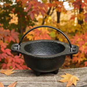 Baby Witch Cauldron: witchcraft supplies & wiccan ritual tools. Witches cauldron close up and outside, midsummer, natural light. Baby Witch Cauldron: witchcraft supplies & wiccan ritual tools. Witches cauldron close up and outside, midsummer, natural light.